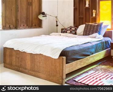 Vintage bedroom interior design with wooden bed and yellow glass window.