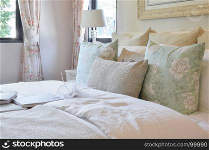 vintage bedroom interior with flower pillows and decorative table lamp