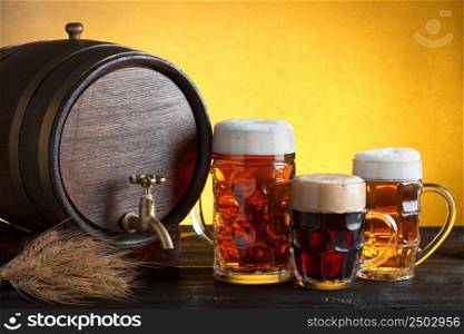 Vintage beer barrel with beer glasses on wooden table with wheat bunch, still life with copy space