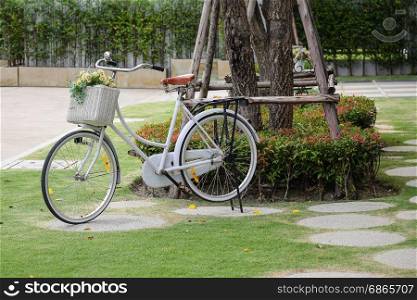 vintage bicycle at garden with artificial flowers in basket