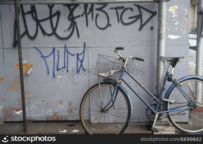 Vintage Bicycle Leaning Against Wall With Graffiti