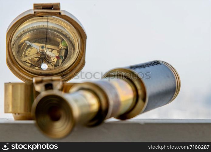 Vintage Binocular and Antique bronze emblem compass (Old compass) with Sky Background. Journey Concept. Copy Space. Vintage Style