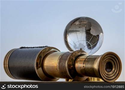 Vintage Binocular and Crystal Globe with Sky Background. Travel Concept. Copy Space. Vintage Style