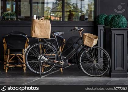 Vintage black bicycle parked in front of cafe and restaurantExterior design and frontstore decoration, Selective focus.