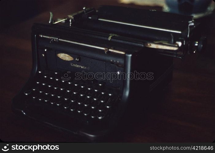 Vintage black Underwood typewriter on a dark wooden desk