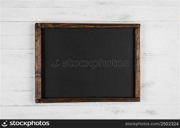 Vintage blank chalkboard on white wooden background