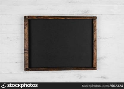 Vintage blank chalkboard on white wooden background