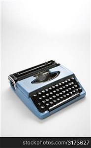 Vintage blue typewriter on white background.
