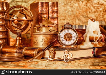 Vintage book, compass, telescope and a pocket watch lying on ancient world map in 1565.