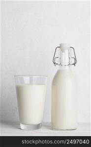Vintage bottle of milk and glass of milk on white wooden table background