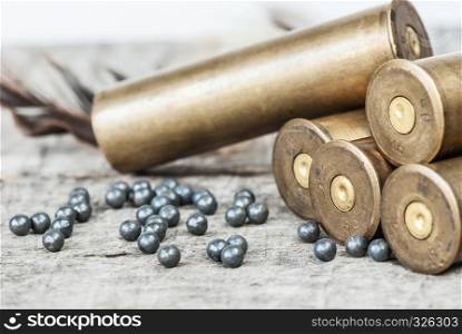 Vintage brass hunting cartridges and large lead shot on an old wooden background close-up