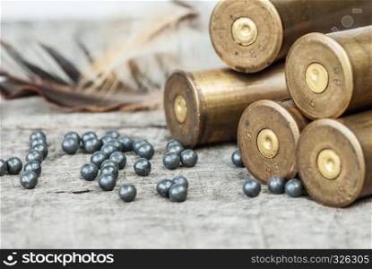 Vintage brass hunting cartridges and large lead shot on an old wooden background close-up