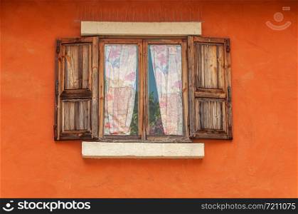 Vintage brown wooden window on orange cement wall
