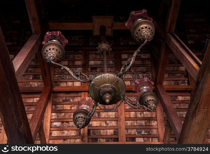 Vintage chandelier hang in wooden room look from uprisen angle
