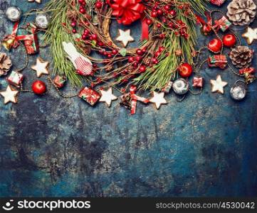 Vintage Christmas background with red decoration, wreath of red winter berries and cookies, top view, horizontal border