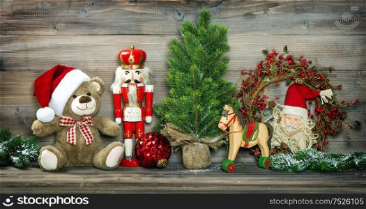 Vintage Christmas decoration Teddy Bear, Rocking Horse and Nutcracker. Retro style colored photo with vignette
