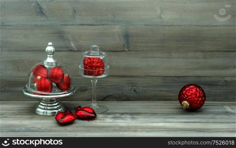 Vintage christmas decoration with red baubles over rustic wooden background. Nostalgic still life. Retro style toned picture