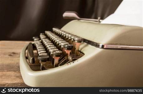 vintage classic cyrillic typewriter with blank sheet of paper inserted on wooden table close-up