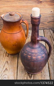 Vintage clay pitchers on wooden background. Studio Photo. Vintage clay pitchers on wooden background