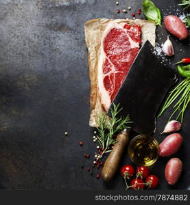 vintage cleaver and raw beef steak on dark background