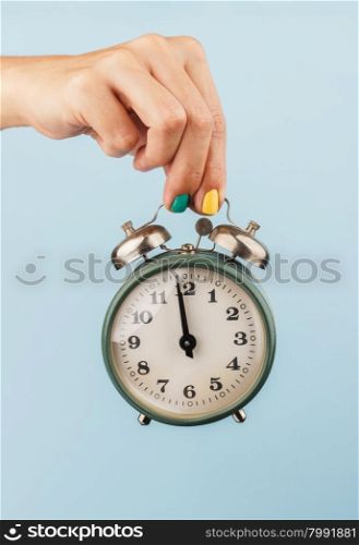 vintage clock in a woman&amp;#39;s hand on the blue background
