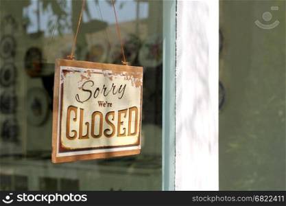 vintage closed sign hanging in front of shop window