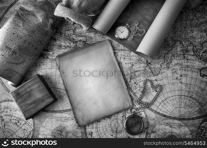 Vintage compass and a pocket watch lying on old map