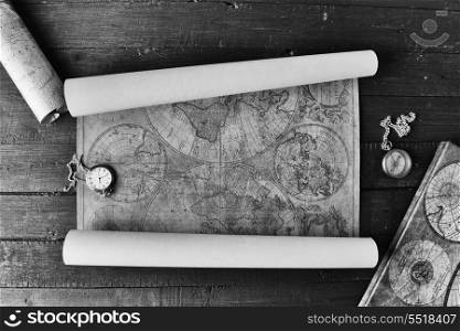 Vintage compass and a pocket watch lying on old map