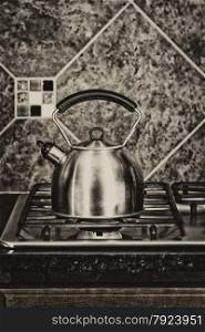 Vintage concept of a stainless steel tea pot on stove top.