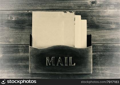 Vintage concept of an old metal mailbox with letters inside on rustic wood
