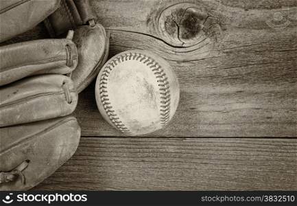 Vintage concept of old baseball and mitt on rustic wood. Layout in horizontal format. Slight vignette on border.