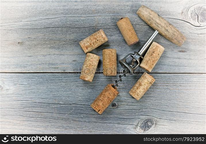 Vintage concept of several used wine corks and opener on rustic wooden boards.