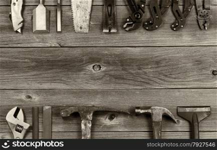 Vintage concept of used partial tools forming border on rustic wooden boards.