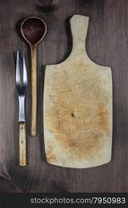 Vintage cutting board with wooden spoon, two-pronged fork and space for text