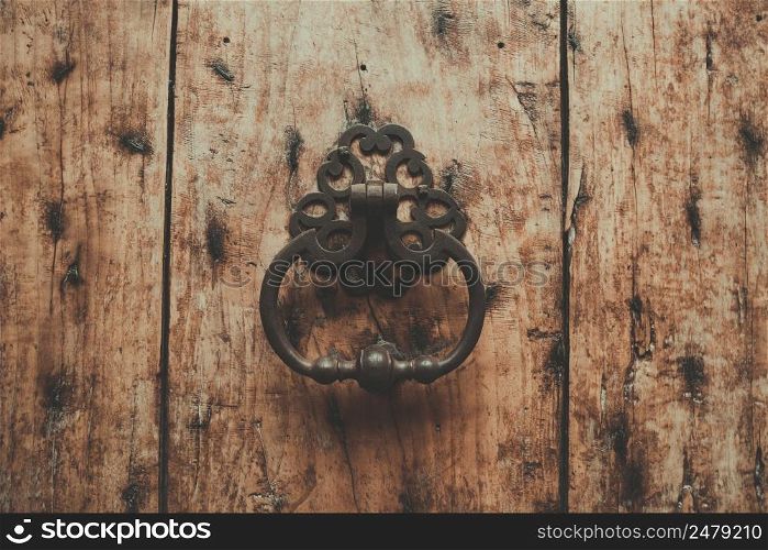 Vintage door knocker on old wooden front door retro toned