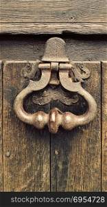 Vintage doorknocker close-up on weathered wooden door background, Troyes, France