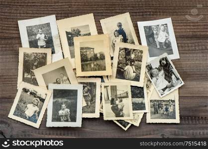 Vintage family photos on wooden table. Old pictures used paper