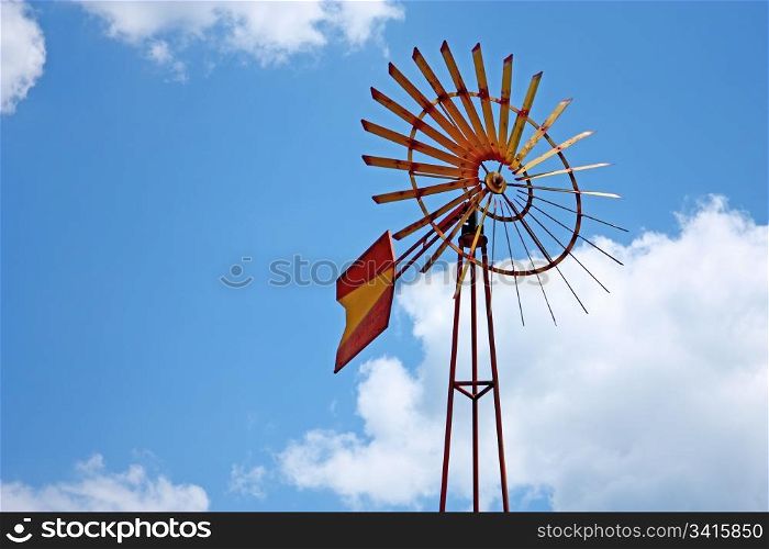 Vintage farm windmill against blue sky