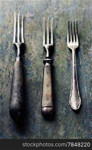 Vintage forks on rustic wooden background