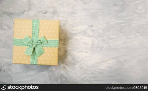 Vintage gift box with ribbon and bow on concrete gray background top view with copy space
