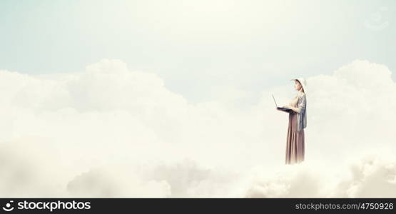 Vintage girl with laptop. Young lady standing on cloud and using laptop