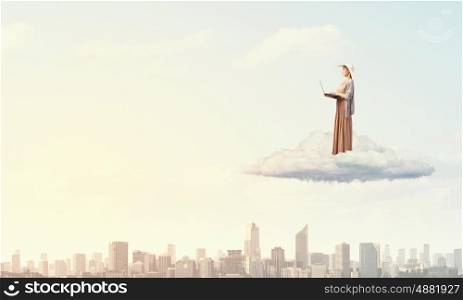 Vintage girl with laptop. Young lady standing on cloud and using laptop