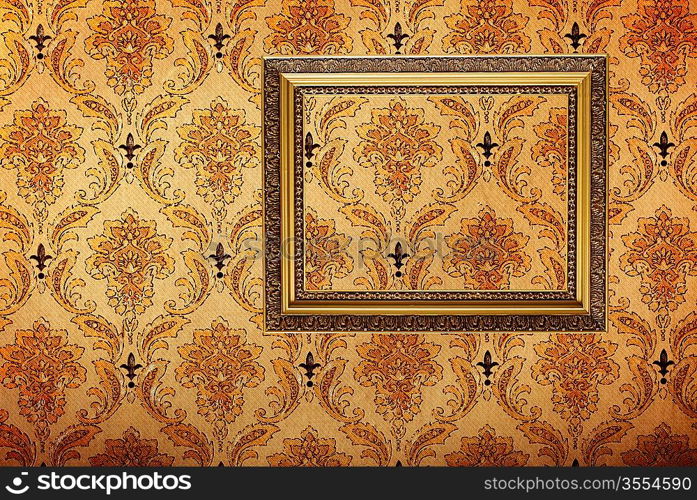 Vintage gold plated picture frame on retro wallpaper background