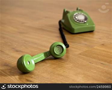 Vintage green phone over a wood floor