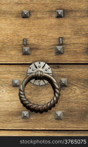 Vintage grunge wooden background door gate of the old castle detail with metal rivets and knocker handle