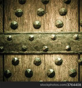 Vintage grunge wooden background door gate of the old castle detail with metal rivets. Square format