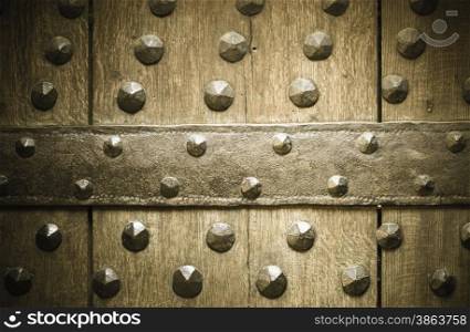 Vintage grunge wooden background door gate of the old castle detail with metal rivets