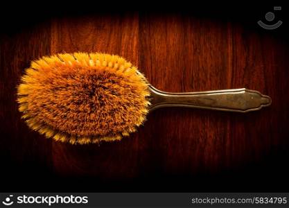 Vintage hairbrush on solid dark wood