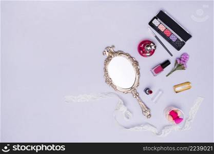 vintage hand mirror lipstick nail varnish sponge perfume bottle eyeshadow palette purple background