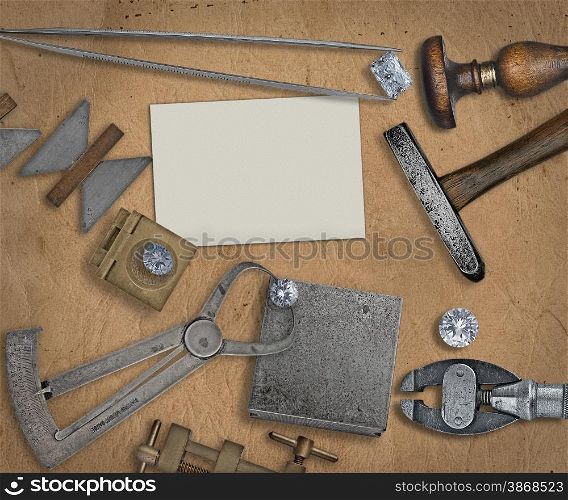 vintage jeweler tools and diamonds over working bench, blank business card for your text